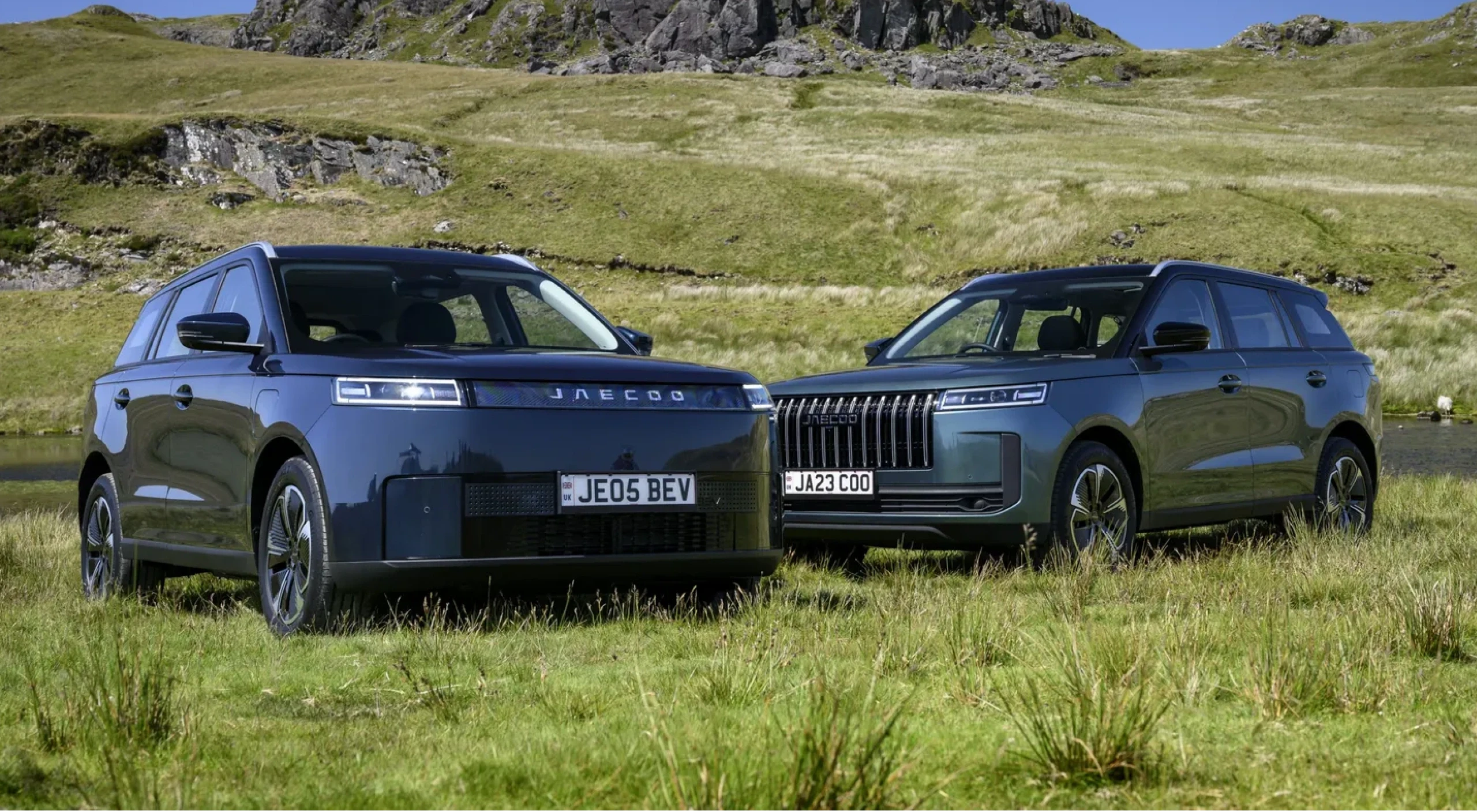 A JAECOO 5 and JAECOO 7 parked side by side on a Highland hillside, with the JAECOO wordmark behind them