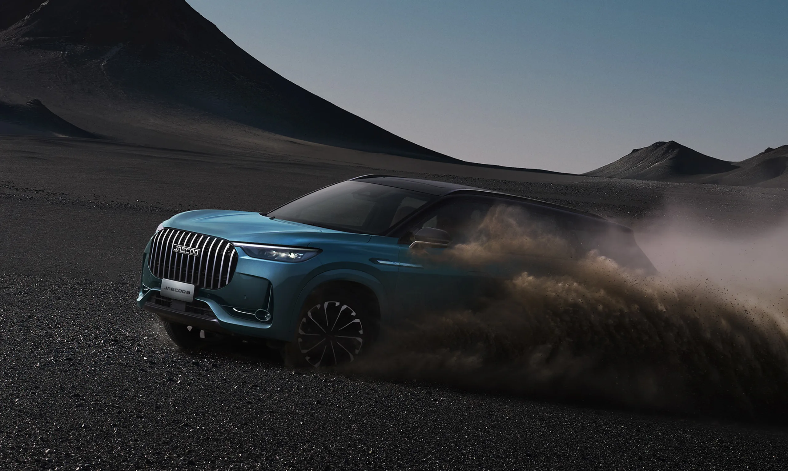 JAECOO 8 driving across black volcanic sand, throwing up dust, with the words SHS TECH behind it